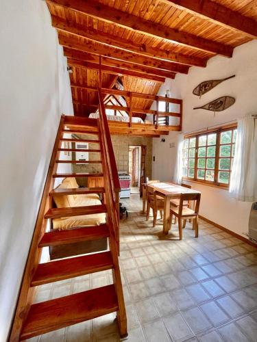 圣卡洛斯-德巴里洛切Casa para descansar的客房设有木制楼梯和桌子。