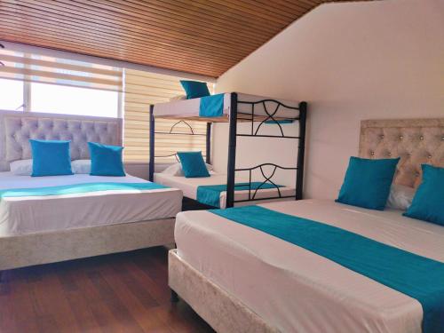 波哥大Hotel Batan 127的蓝色和白色的客房内的两张床