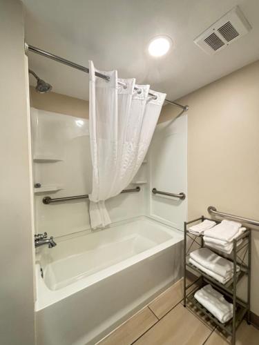 莱克帕克Baymont by Wyndham Lake Park Valdosta I75的白色的浴室设有浴缸和淋浴。