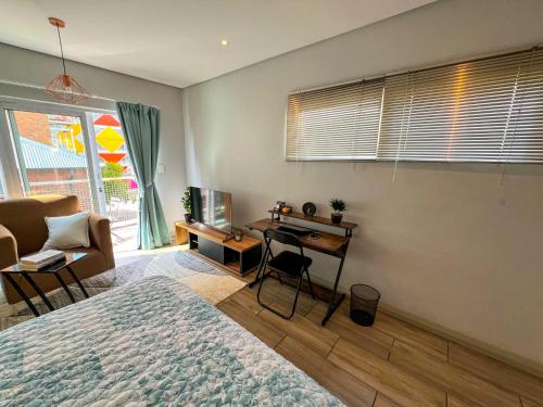 约翰内斯堡Entire Studio Apartment in Maboneng的一间卧室配有一张床和一张书桌