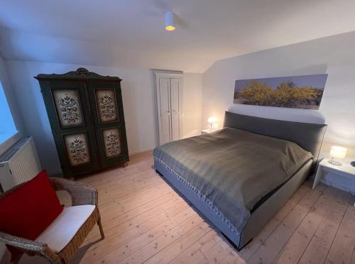 伦格里斯NEU - traumhafte Ferienwohnung mit Bergblick的一间卧室,卧室内配有一张床和一把椅子