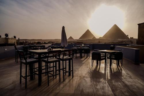 开罗Pyramids Inn的一组有金字塔背景的桌椅