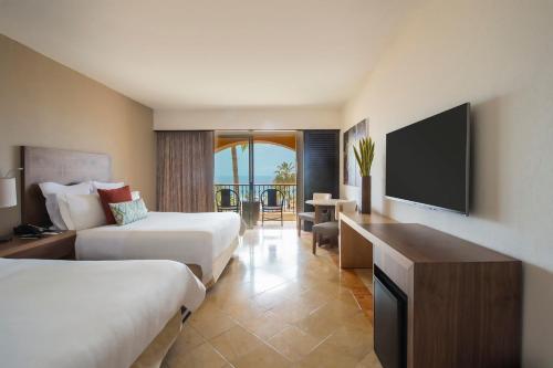 卡波圣卢卡斯盛大嘉年华美洲洛斯卡沃斯全包高尔夫温泉酒店的酒店客房设有两张床和一台平面电视。