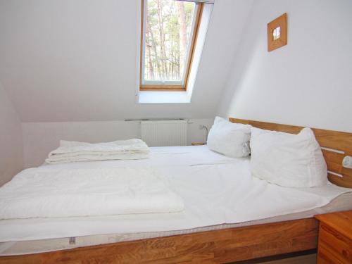 特拉森海德Apartment house, Trassenheide的一间卧室配有一张带白色床单的床和一扇窗户。