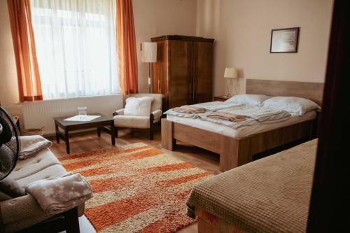 久洛Dobay Apartman Gyula的一间卧室配有一张床、一把椅子和一张沙发
