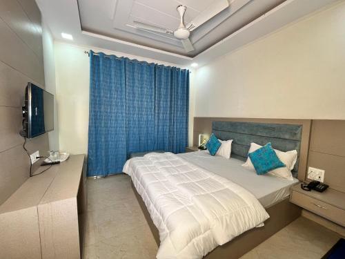 哈尔德瓦尼Cosy stay的一间卧室配有一张带蓝色窗帘的大床