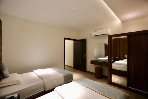 Rabbaكيان للأجنحة الفندقية- احد رفيده的酒店客房,配有床和镜子