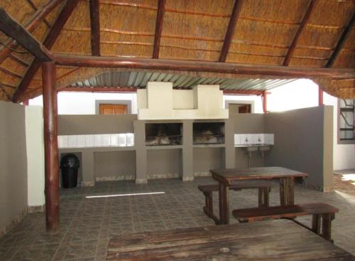 贝拉贝拉BelaBela Guesthouse的大楼内带桌子和长凳的房间