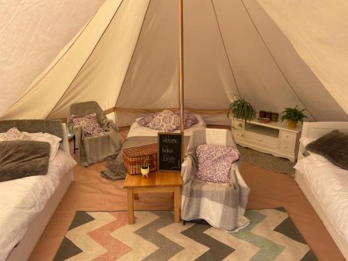 赫尔斯顿Trevena Cross Glamping的一个带两张床和一张桌子的帐篷