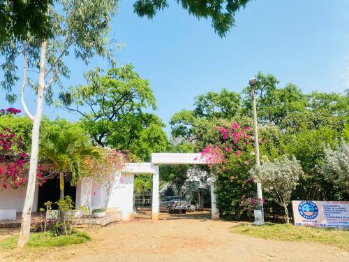 圣玛尔塔HOSTAL OLAS CLUB DE NEGUANJE -TAYRONA的一座拥有粉红色花卉的建筑的入口
