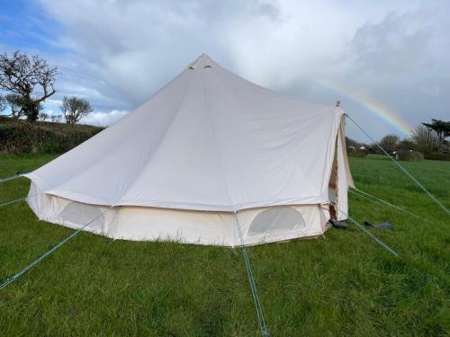 赫尔斯顿Trevena Cross Bell Tent的一块带彩虹的田野上的白色帐篷