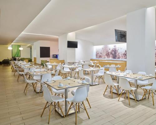 杜兰戈杜兰戈嘉年华酒店的用餐室配有白色的桌子和白色的椅子