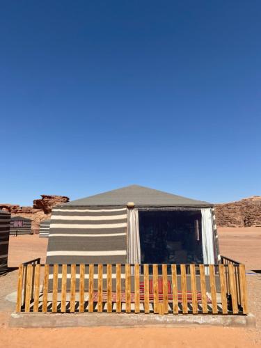 瓦迪拉姆Glamp Camp Wadi Rum的沙漠中带有栅栏的建筑物