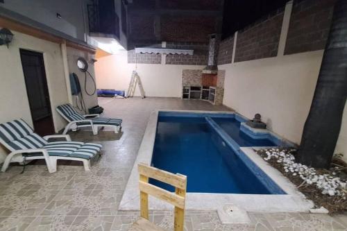 库奥特拉莫雷洛斯Casa Completa con Alberca, Sola, 3 habitaciones AC, Atras del Balneario Agua Hedionda totalmente Privada的一个带两把椅子和一张桌子的游泳池