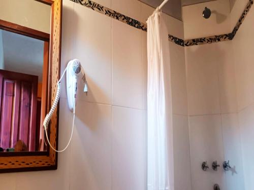 普尔马马尔卡Ipay Alojamiento Familiar的墙上设有带吹风机和淋浴的浴室