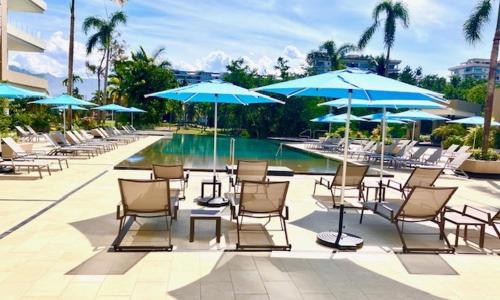 巴亚尔塔港Casa Cielo Vallarta V-Golf的一组椅子和遮阳伞,位于游泳池旁