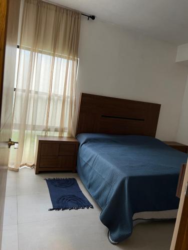 蒙特雷Nohemani Suite的一间卧室设有蓝色的床和窗户。