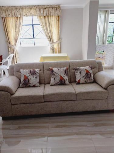 CarazDEPA CENTRICO CARAZ的客厅配有带枕头的棕色沙发