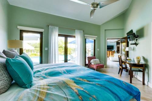 珀拉什奇亚Luxury Villa, Perfect for Groups. Stunning Pool. Allamanda del Mar的一间卧室配有一张蓝色的床、书桌和窗户