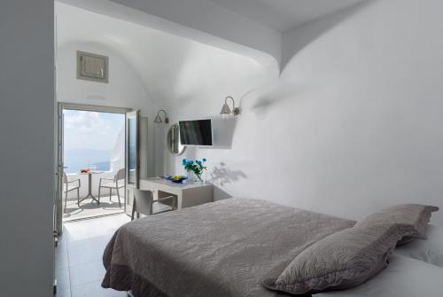 易莫洛林克隆纳斯别墅酒店的一间白色卧室,配有床和阳台