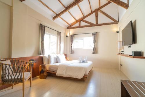 爱妮岛Nacpan Beach Villas的一间卧室配有一张床,并在一间客房内配有电视。