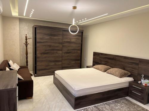 Al Ma‘şarahشقة فندقية فاخرة的一间卧室配有一张大床和一张沙发
