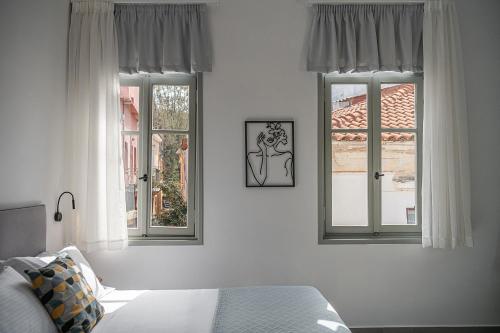 干尼亚Porto Vecchio的一间卧室设有2个窗户和1张床