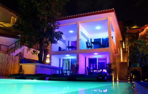 攀瓦海滩Mango Tree Villa的一座房子,在晚上前设有一个游泳池