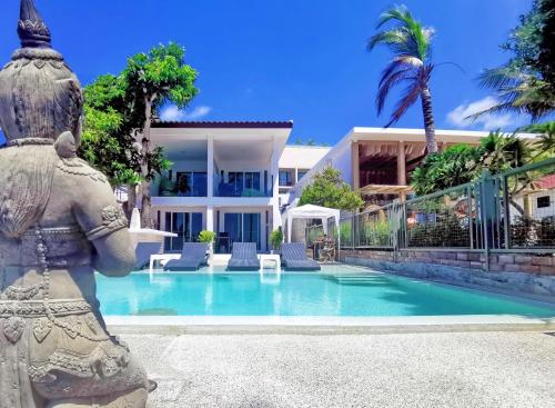 攀瓦海滩Mango Tree Villa的一座别墅,在一座建筑前设有一个游泳池