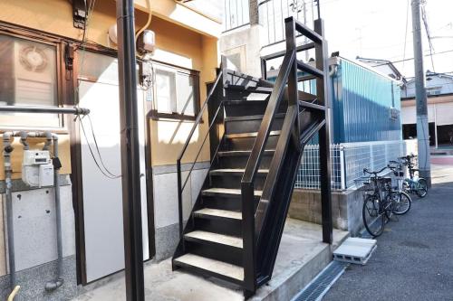 大阪TSUBAME 202 staying private home的通往带自行车的建筑的楼梯