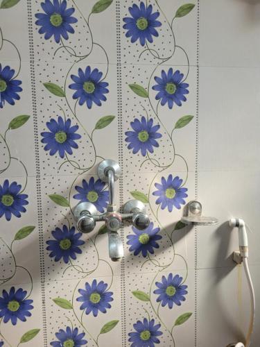 兰奇Mysa Homestay的墙上设有蓝色花卉淋浴的浴室