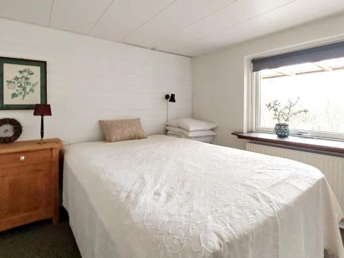 斯凯恩Holiday home Skjern XXI的卧室配有白色的床和窗户。