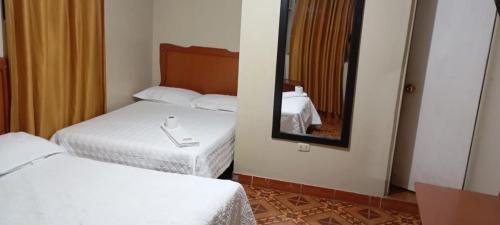 阿亚库乔HOSPEDAJE BUENA VISTA的酒店客房,设有两张床和镜子