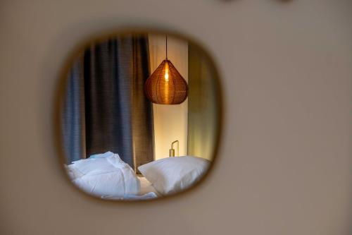 内斯蝴蝶公园公寓的镜子反射着一间卧室,配有两张床和一盏灯