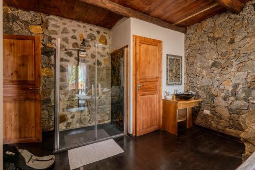 KalawanaJml villa foresta的带淋浴的浴室和石墙