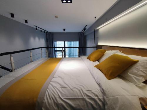 昆明Panda ZuoKe Besucher Apartment 熊猫坐客民宿的一张大白色的床,配有黄色枕头