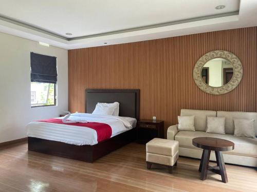 Gadok 1Private Villa 3+1BR in Vimala Hills的一间卧室配有一张床、一张沙发和一面镜子