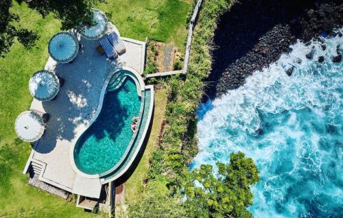 卡朗阿森Bali Cliff Glamping的享有毗邻大海的游泳池的顶部景致
