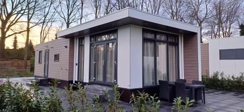 哈尔德韦克Luxe chalet op 4-sterren park met veel faciliteiten - TOPPER的坐在庭院上的一个小房子