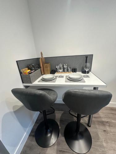 波特里Burnbrae Apartment的一张带两把椅子的白色桌子和一篮子食物