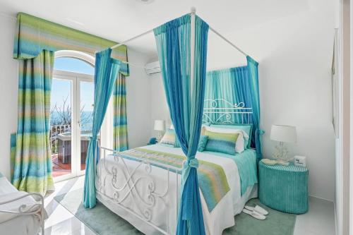 普莱伊亚诺Villa Navarra的一间卧室配有一张带蓝色窗帘的天蓬床
