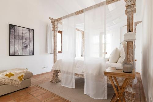 哈隆Cuatre Finques的一间卧室配有一张带白色窗帘和桌子的床
