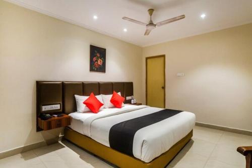 钦奈Blossoms Hotel & Service Apartments的一间卧室配有一张带红色枕头的大床