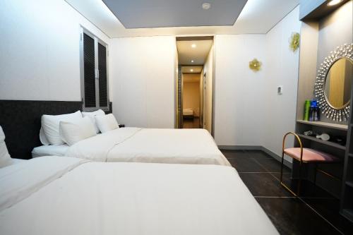 首尔Shinchon Y Hotel的酒店客房,配有两张床和椅子