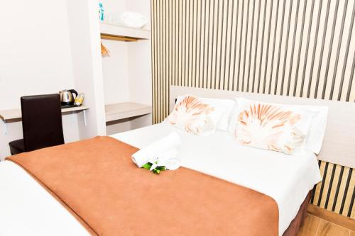菲尼斯特雷Hotel Ancora Urban Center的一间卧室配有带白色床单和枕头的床。