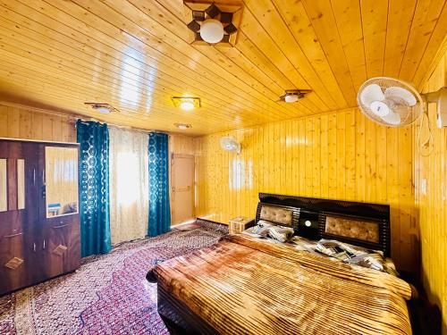 斯利那加Houseboat Newworld and transportation的一间卧室设有一张带木制天花板的大床