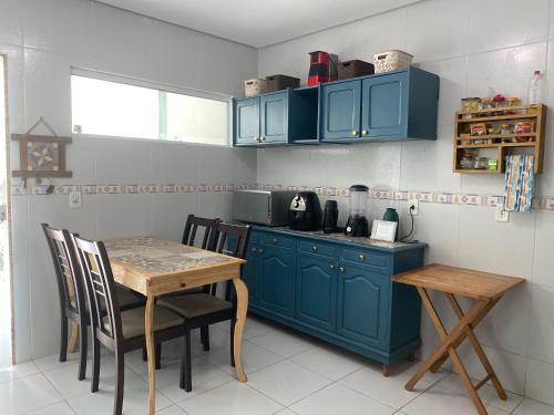 大坎皮纳Duplex agradável com Ar, Internet, Netflix e Estacionamento的厨房配有蓝色橱柜和桌椅
