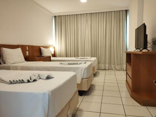 纳塔尔PONTA NEGRA FLAT APART的酒店客房设有两张床和一台平面电视。