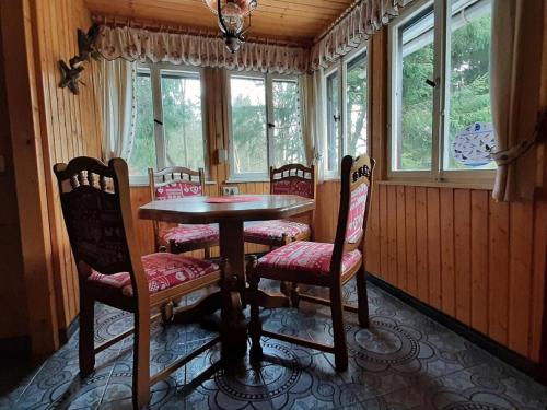 伊尔梅瑙Waldhütte Allzunah的一间带桌椅和窗户的用餐室