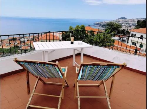 丰沙尔Vila São Gonçalo的阳台上配有一张白色的桌子和两把椅子